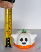 ghost pumpkin next to measuring tape for scale