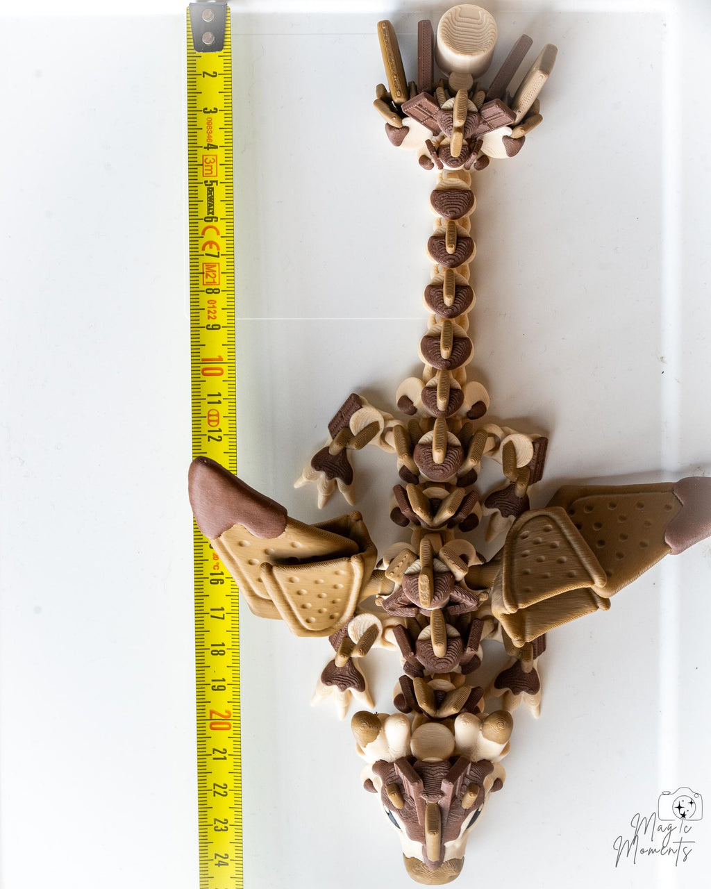 Articulated dragon figure next to measuring tape for scale