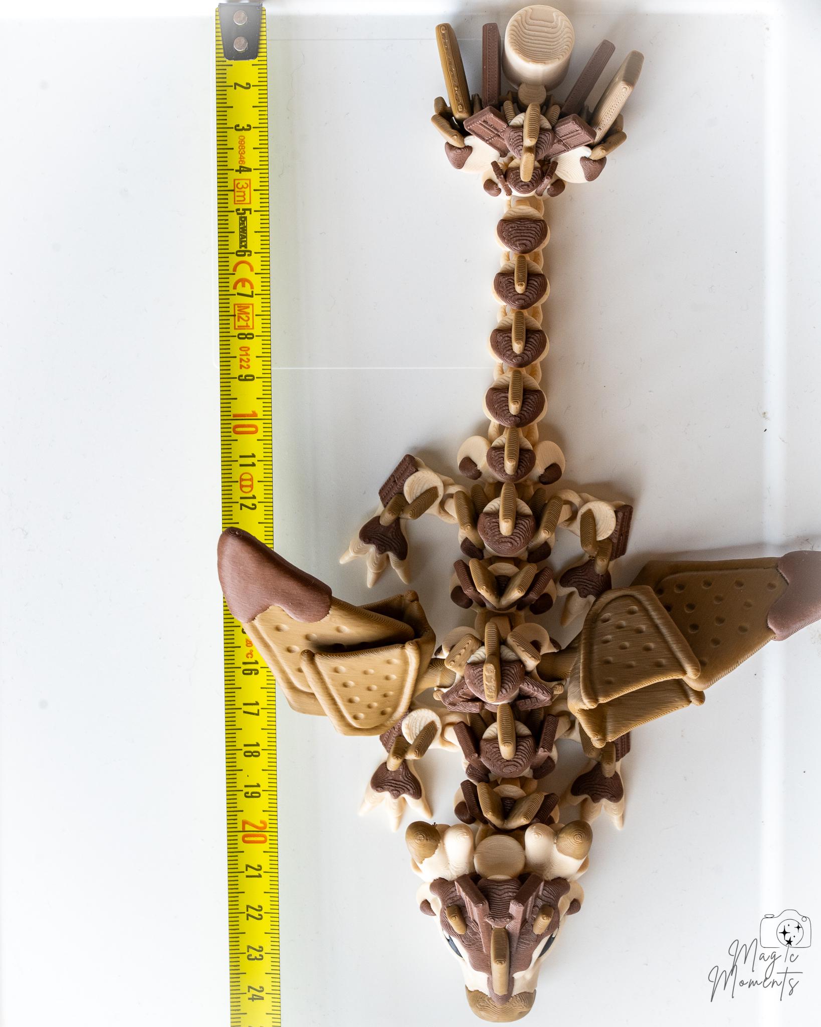 Articulated dragon figure next to measuring tape for scale