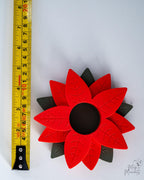 poinsettia tealight holder next to measuring tape for scale
