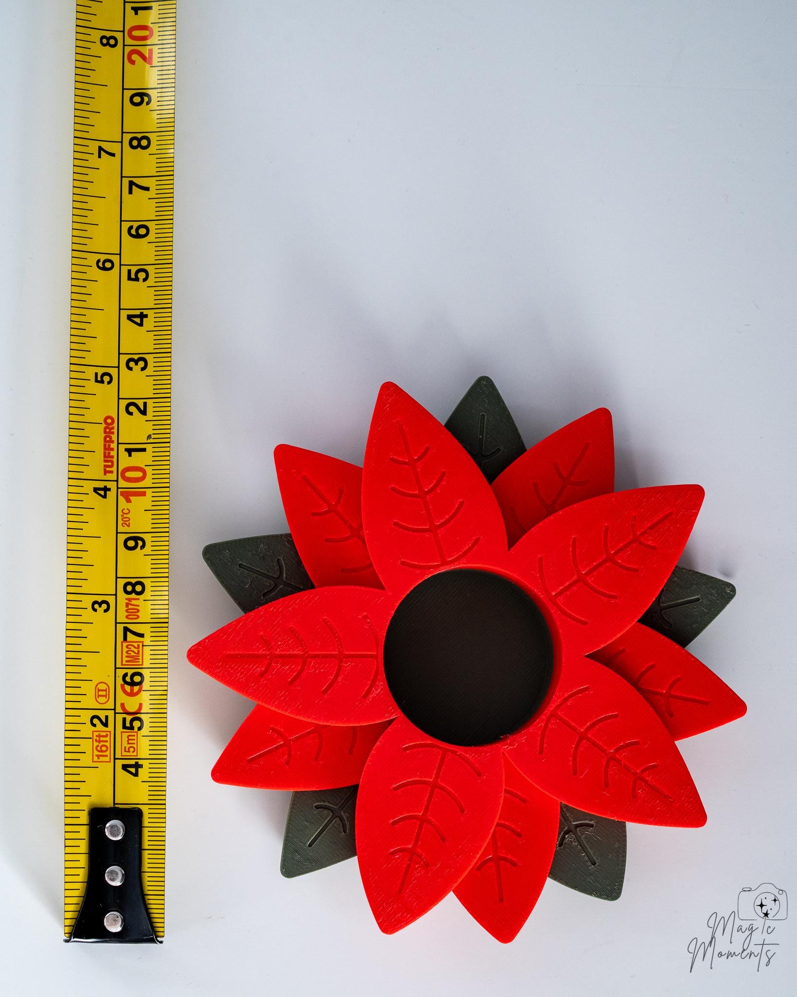 poinsettia tealight holder next to measuring tape for scale