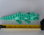 crocodile figure next to measuring tape for scale