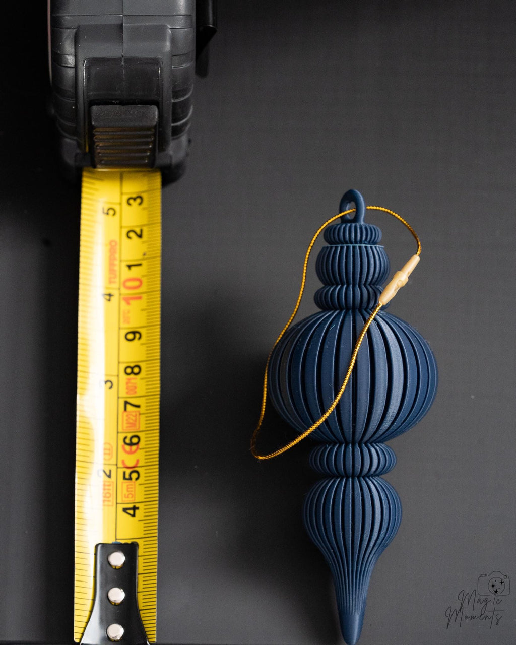 blue modern ribbed christmas bauble next to measuring tape for scale