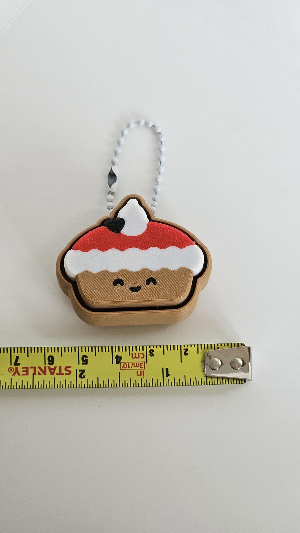 christmas pudding keychain next to measuring tape for scale