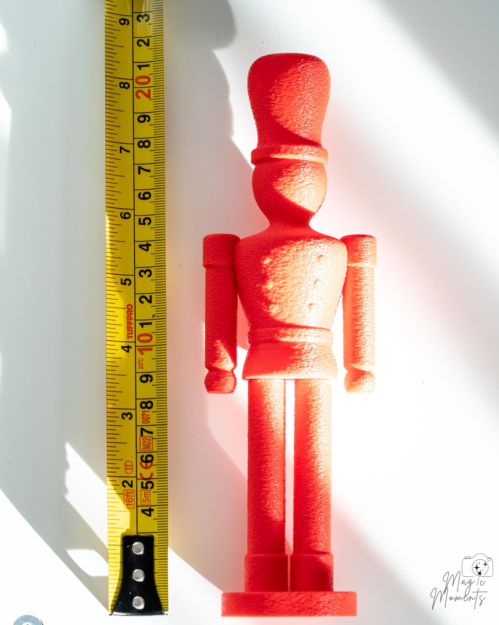 red nutcracker decoration next to measuring tape for scale