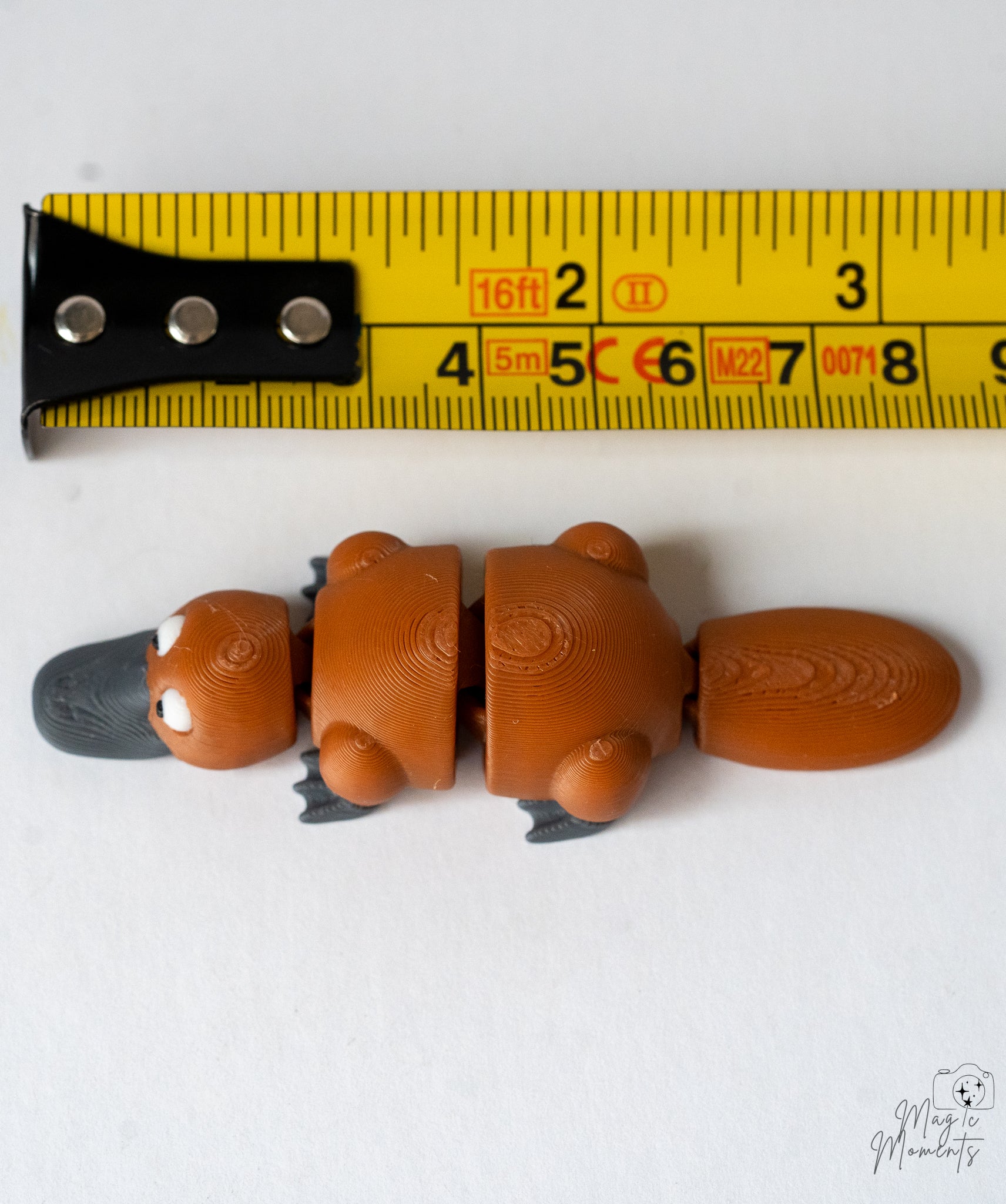 platypus figurine next to a yellow measuring tape for a scale