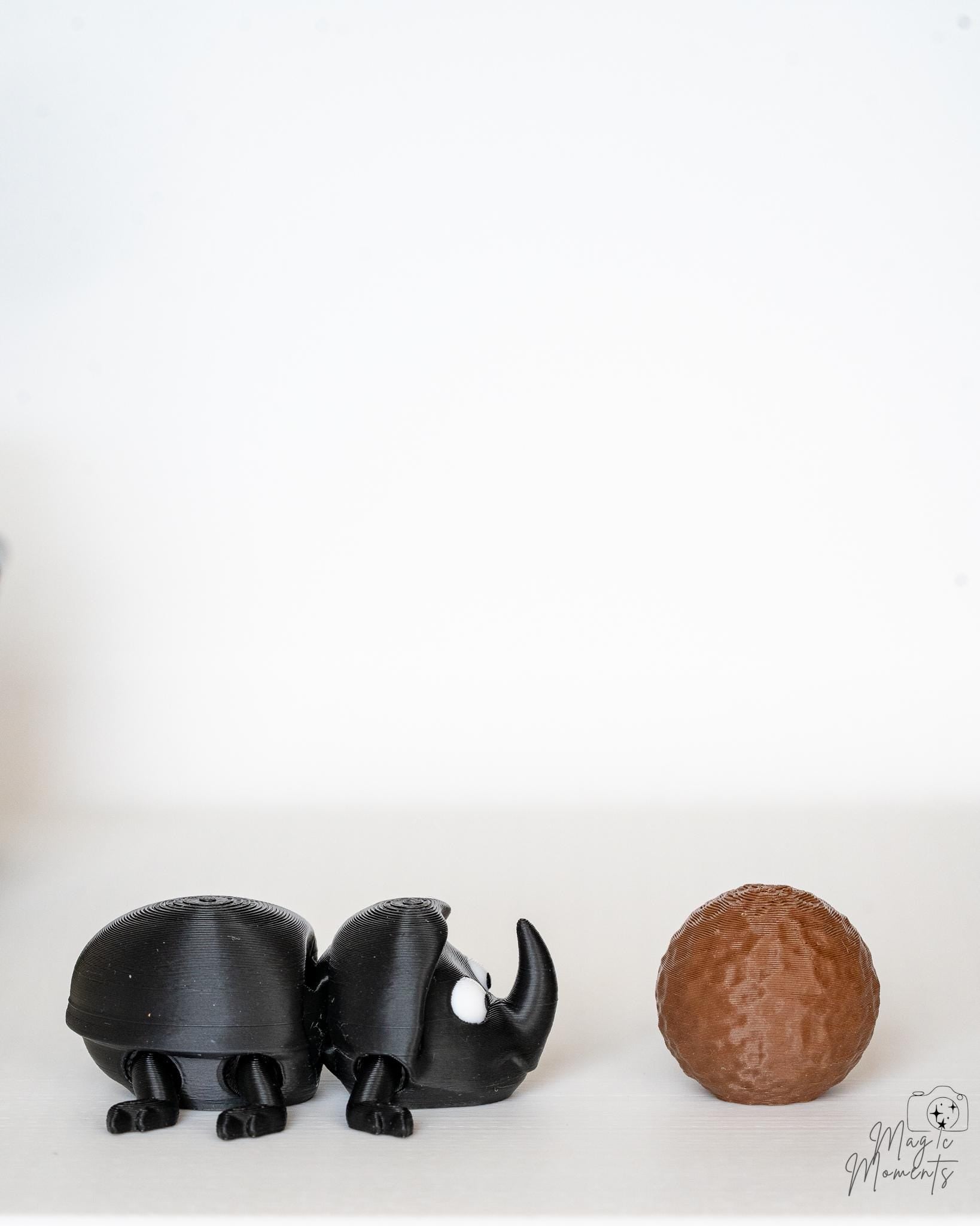 Articulated beetle figure with textured brown dung ball accessory