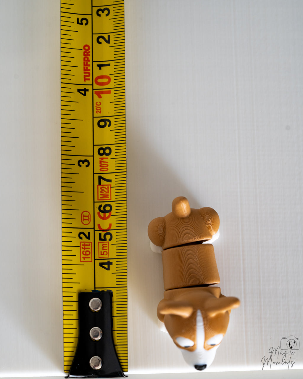corgi figurine next to measuring tape for scale