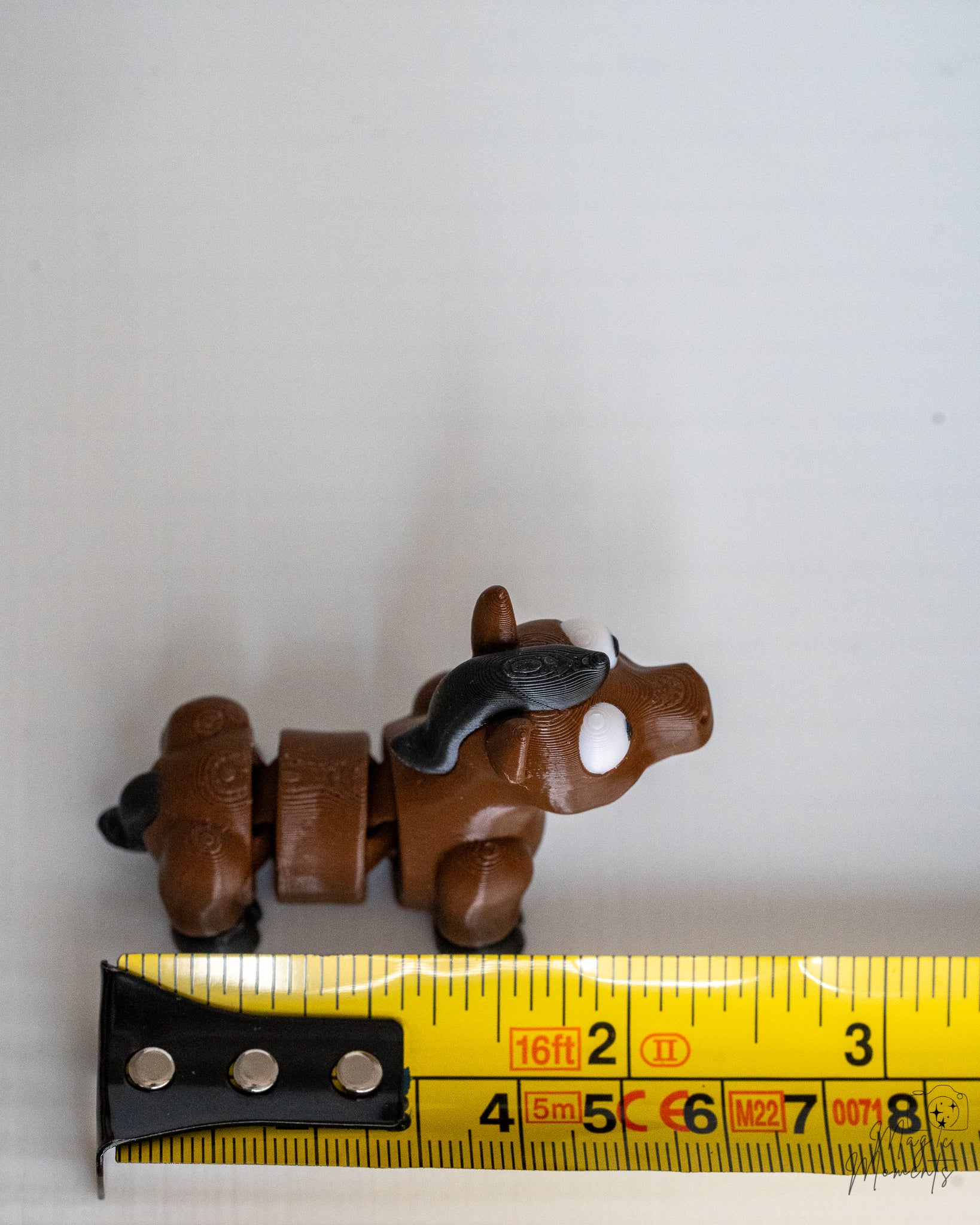 horse figurine next to measuring tape for scale