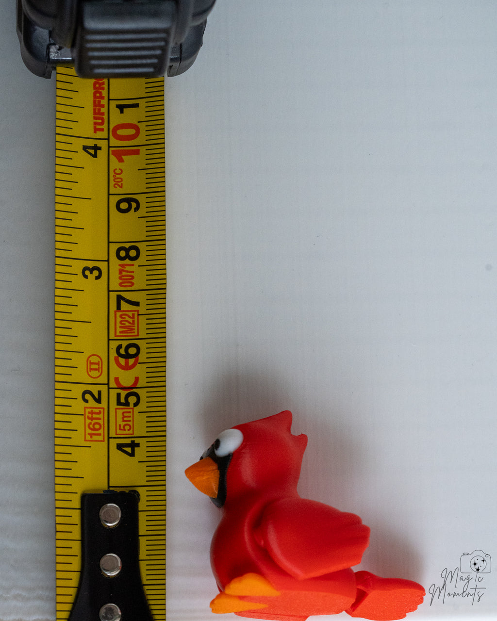 cardinal figurine next to measuring tape for scale