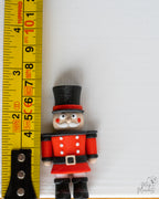 mini nutcracker next to measuring tape for scale