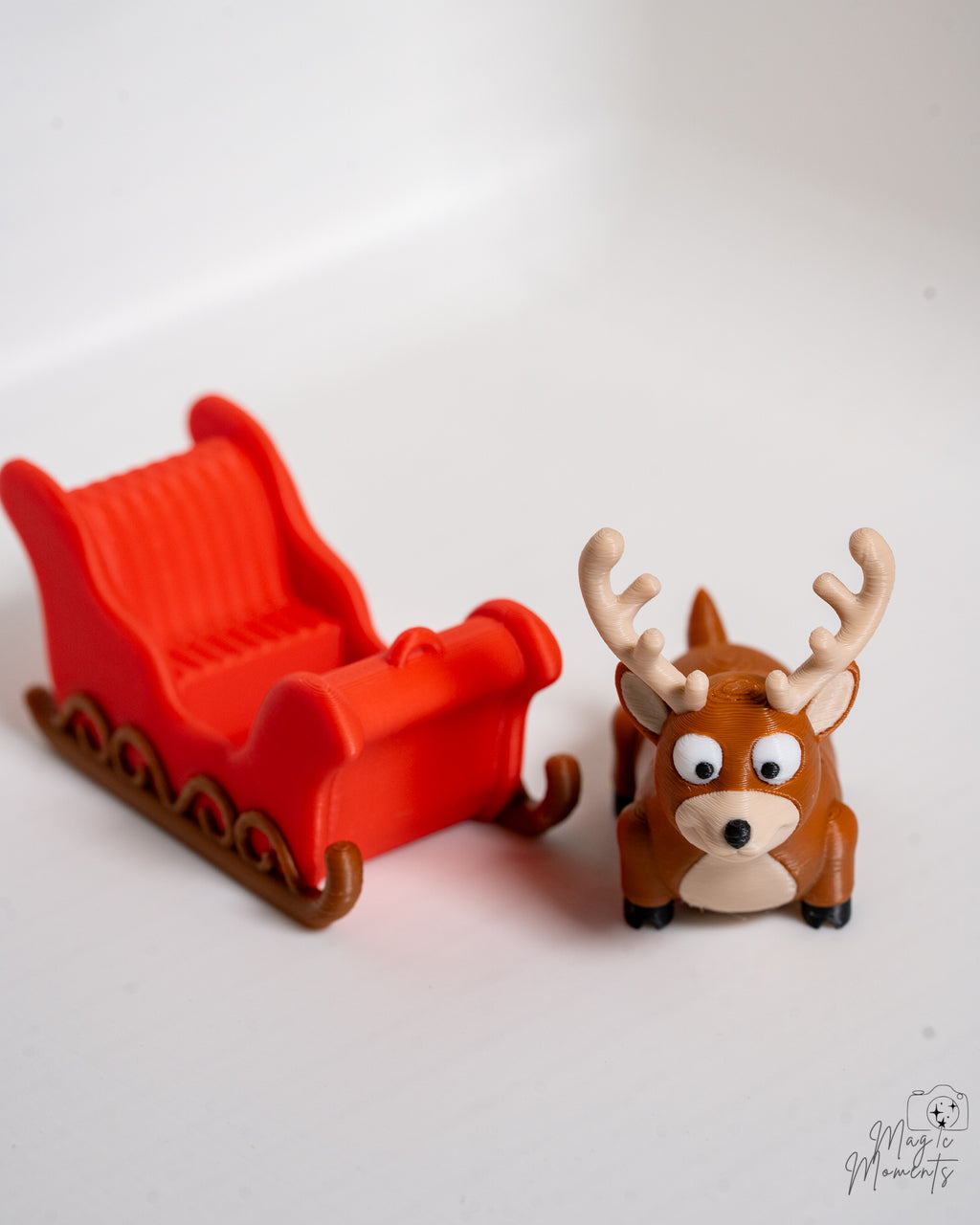Red sleigh with a reindeer figurine on a white background