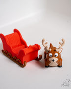 Red sleigh with a reindeer figurine on a white background
