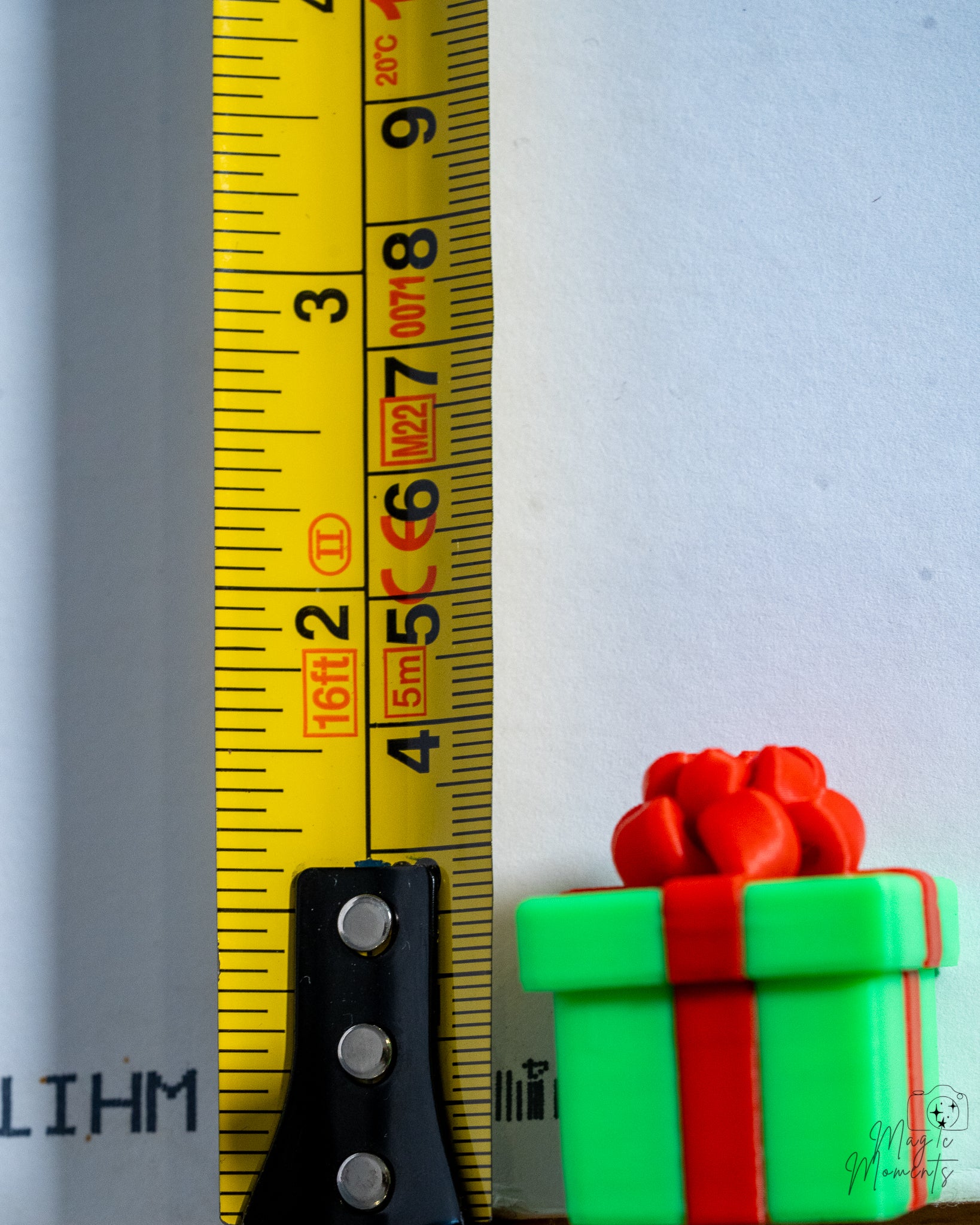 green christmas present clicker next to measuring tape for scale