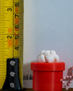 round red christmas gift clicker next to measuring tape for scale