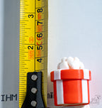 red striped christmas gift clicker next to measuring tape for scale
