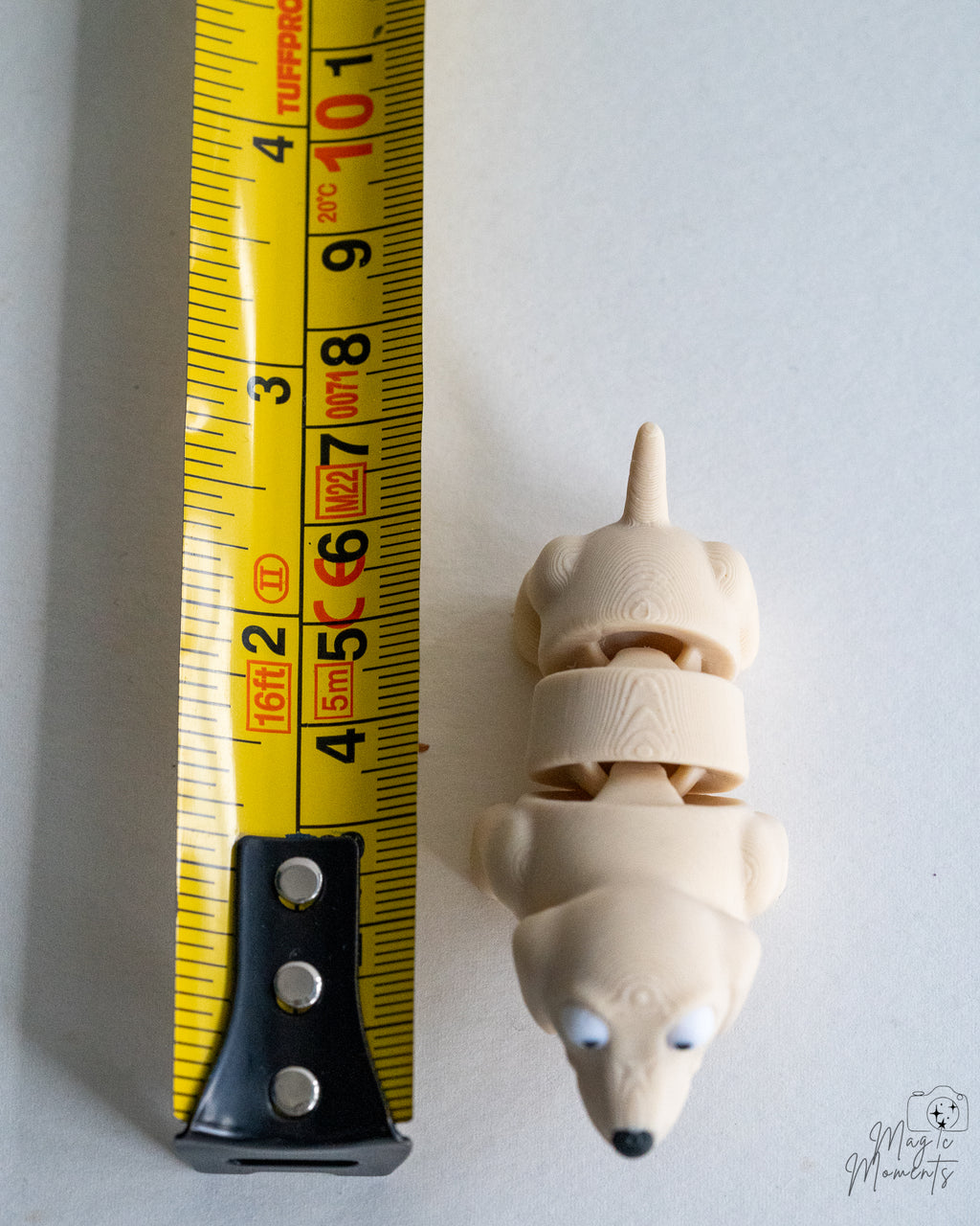Cream dog figure next to measuring tape for scale