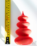 Red Christmas tree decoration next to measuring tape for scale