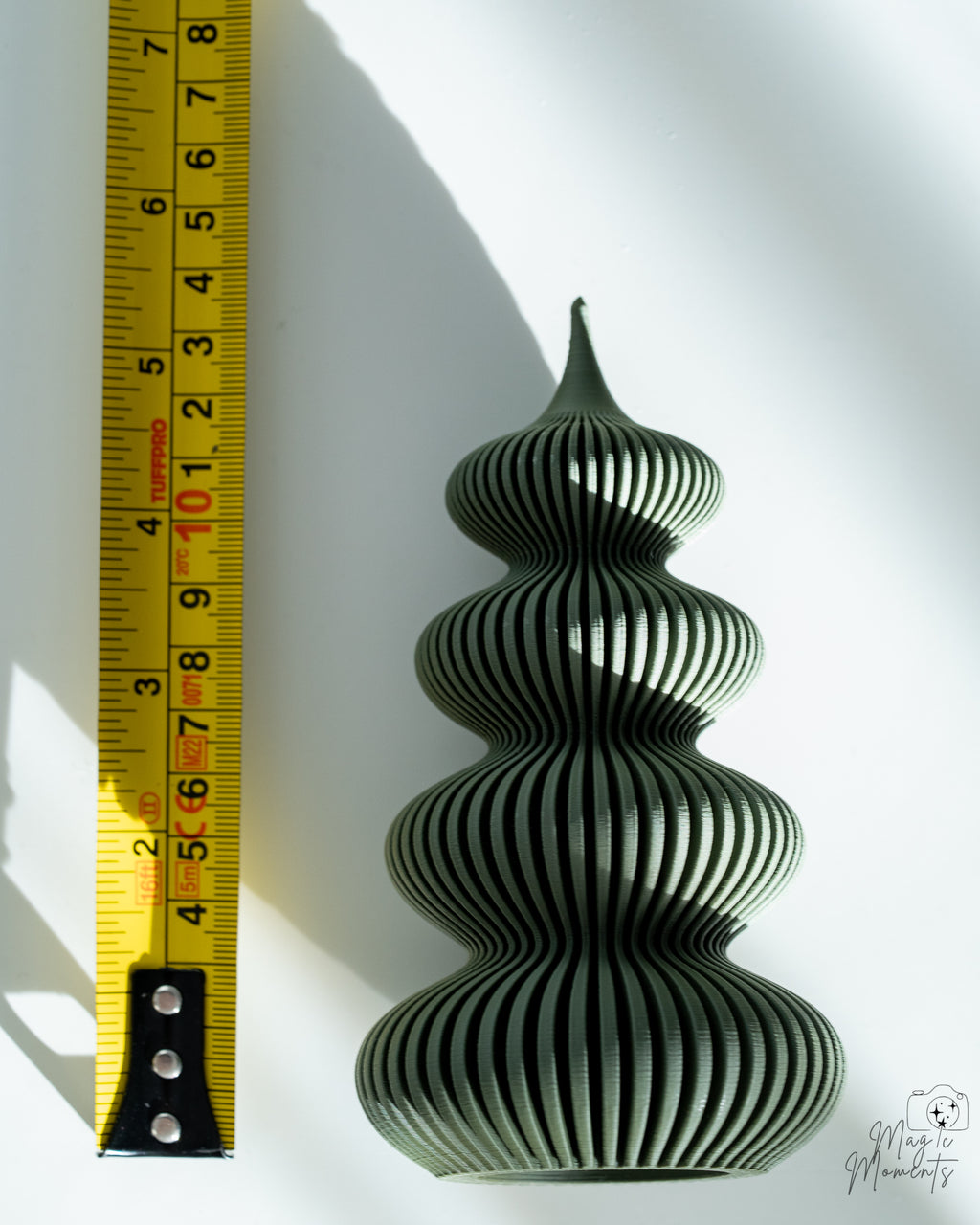 Green Christmas tree decoration next to measuring tape for scale