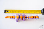 3D printed articulated dinosaur next to measuring tape for scale