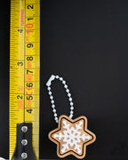 star cookie gingerbread clicker keychain next to measuring tape for scale