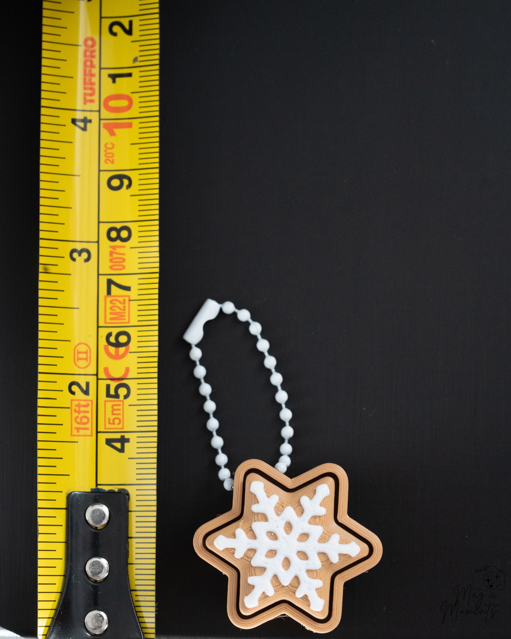 star cookie gingerbread clicker keychain next to measuring tape for scale