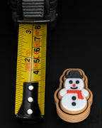 snowman cookie gingerbread clicker keychain next to measuring tape for scale