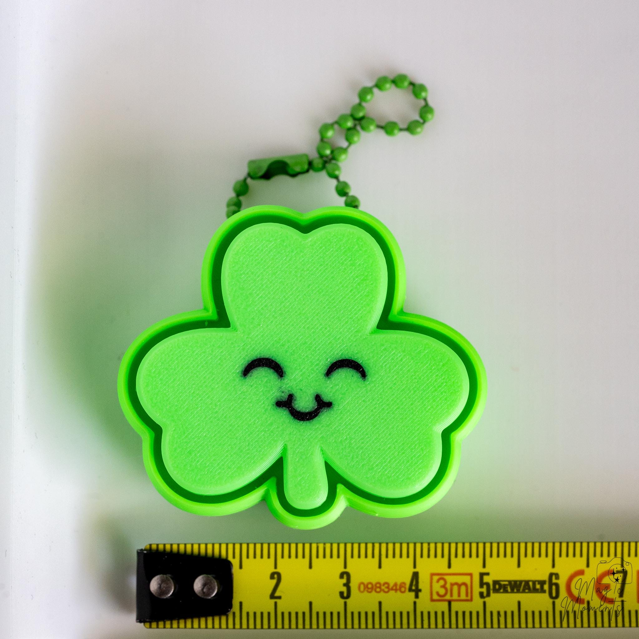 shamrock keychain next to measuring tape for scale