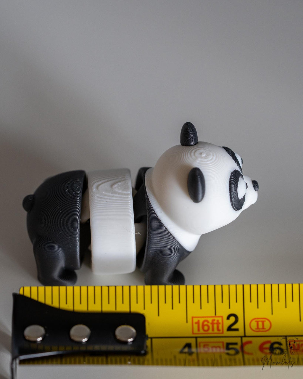 Panda figure next to measuring tape for scale