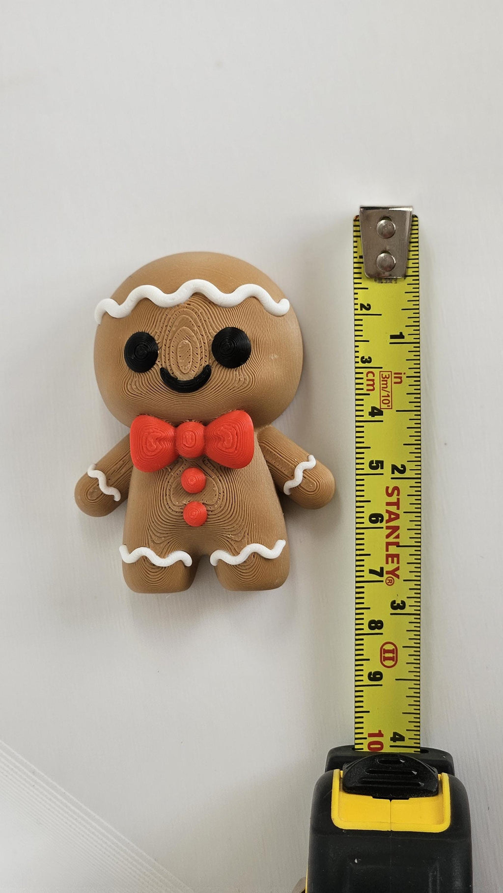 Mini gingerbread man next to measuring tape for scale