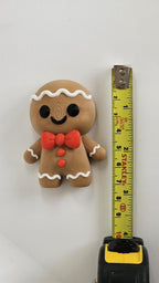 Mini gingerbread man next to measuring tape for scale