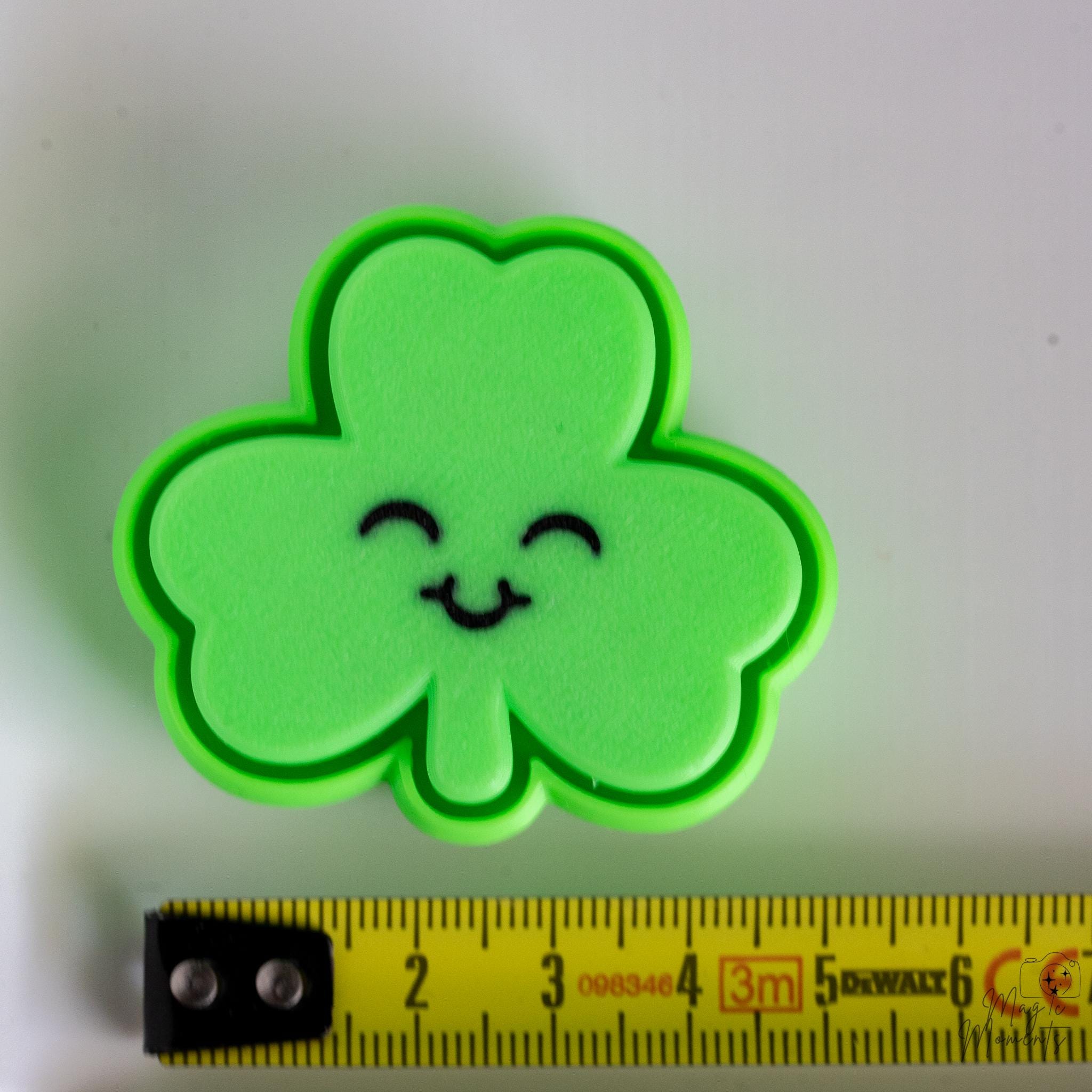 clover clicker next to measuring tape for scale