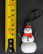 Snowman ornament next to measuring tape for scale