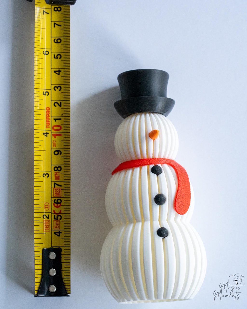 Snowman decoration next to measuring tape for scale