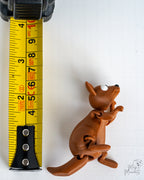 kangaroo figurine next to a yellow measuring tape for a scale