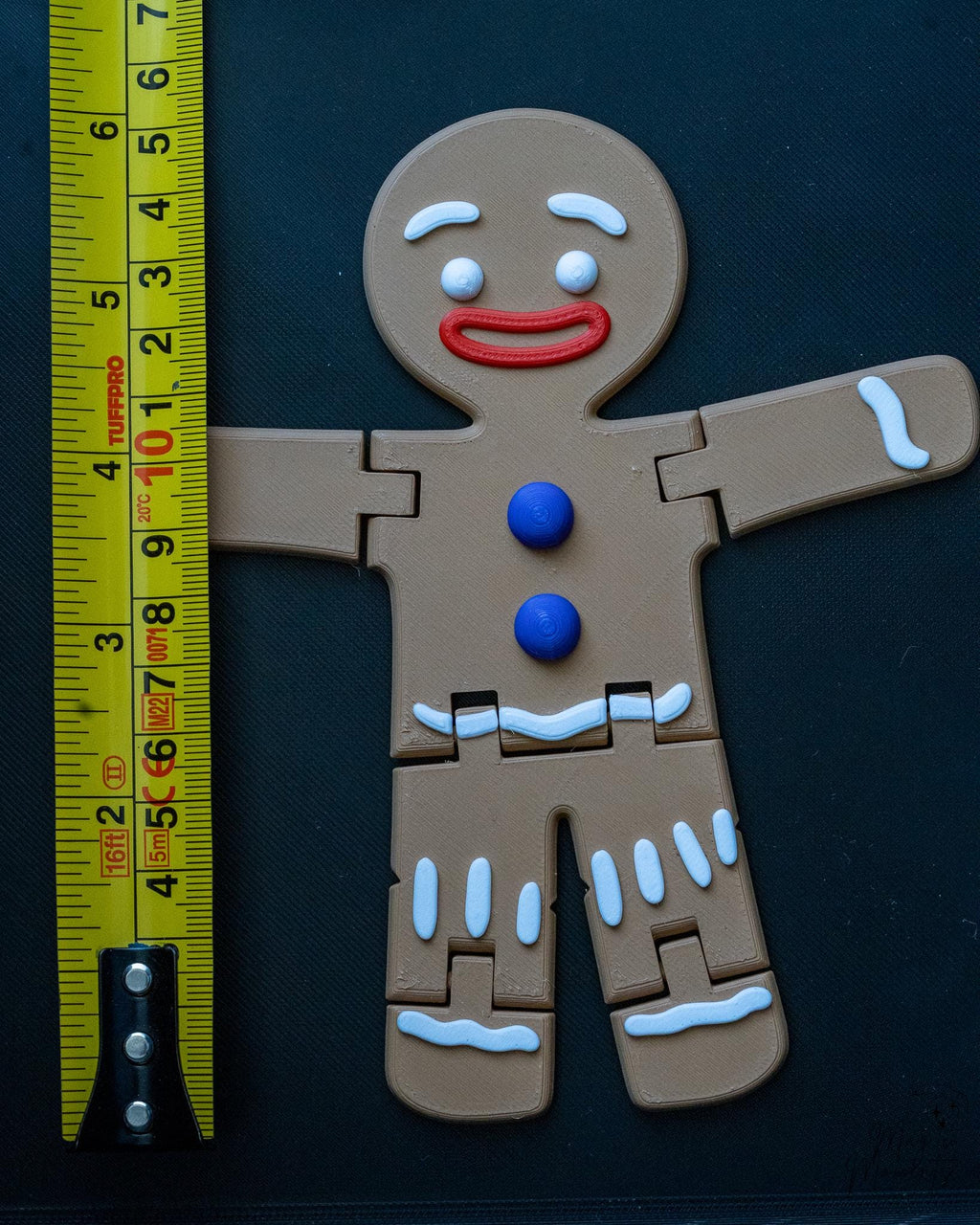 gingerbread man articulated figure next to measuring tape for scale