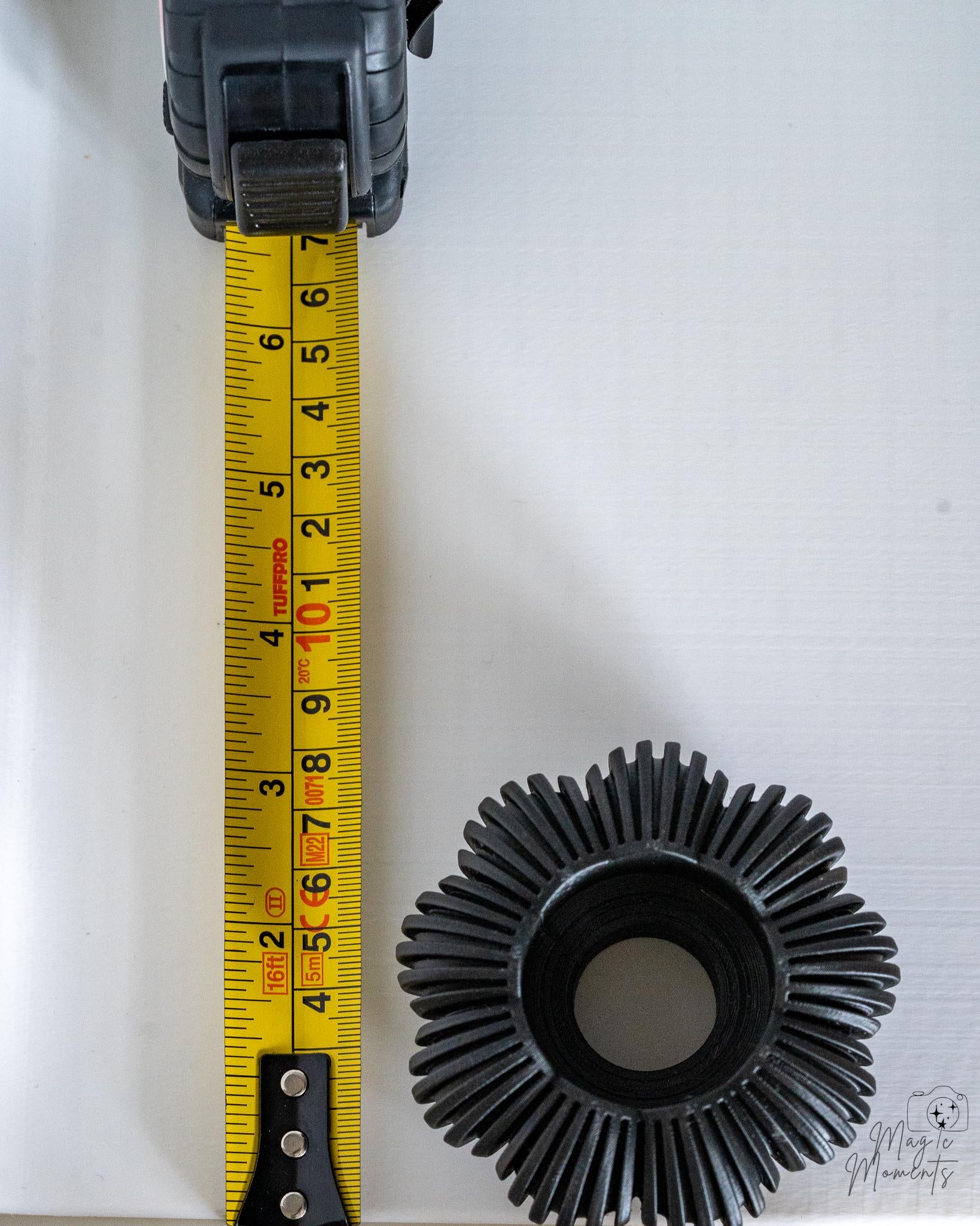 Grey pumpkin tealight holder viewed from above next to measuring tape for scale