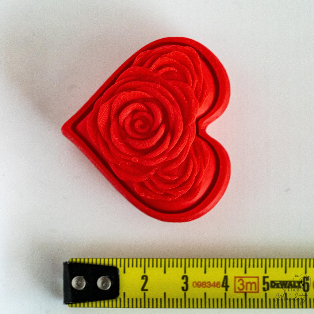 rose heart clicker next to measuring tape for scale