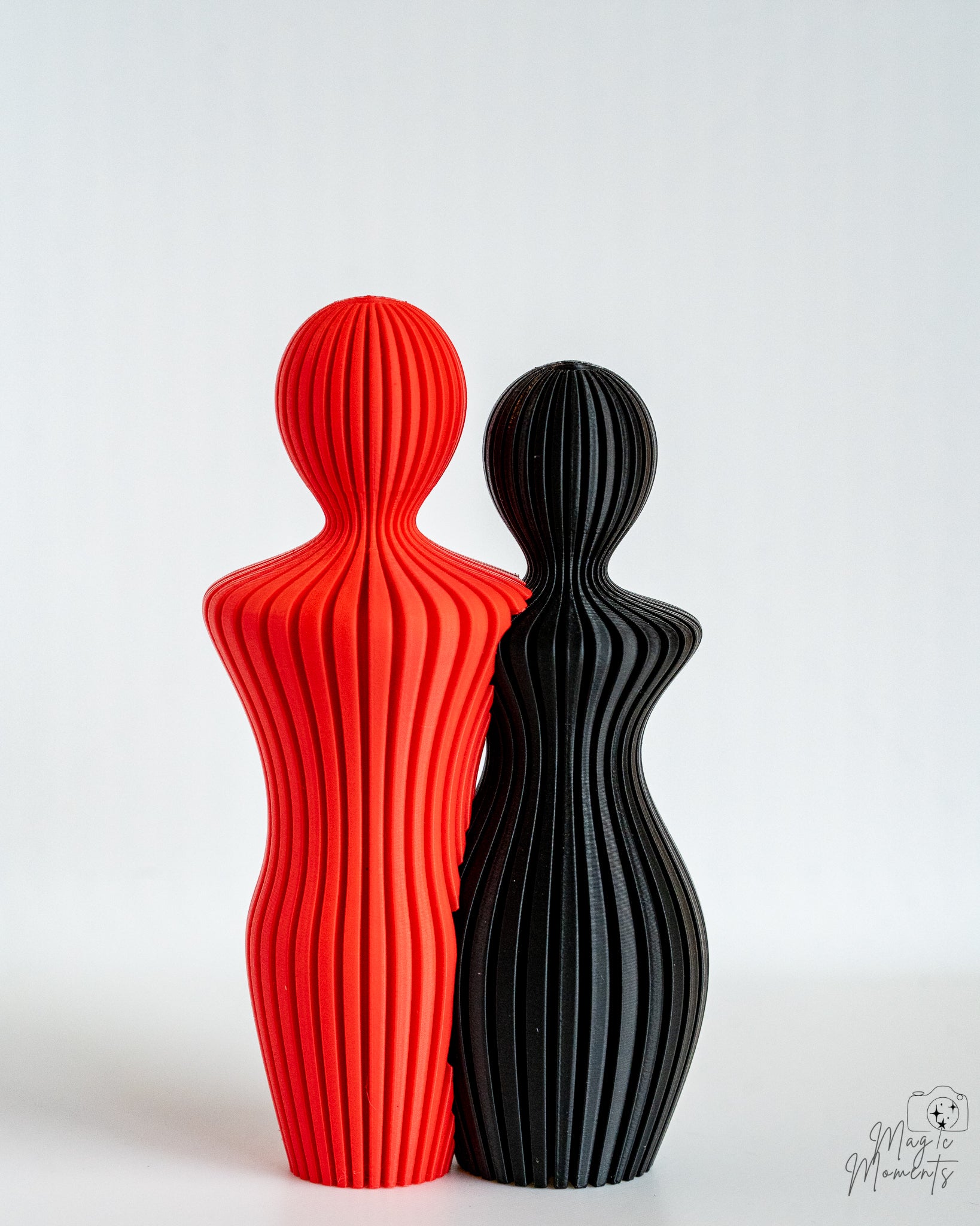 Red and black couple sculpture pair with minimalist ribbed texture