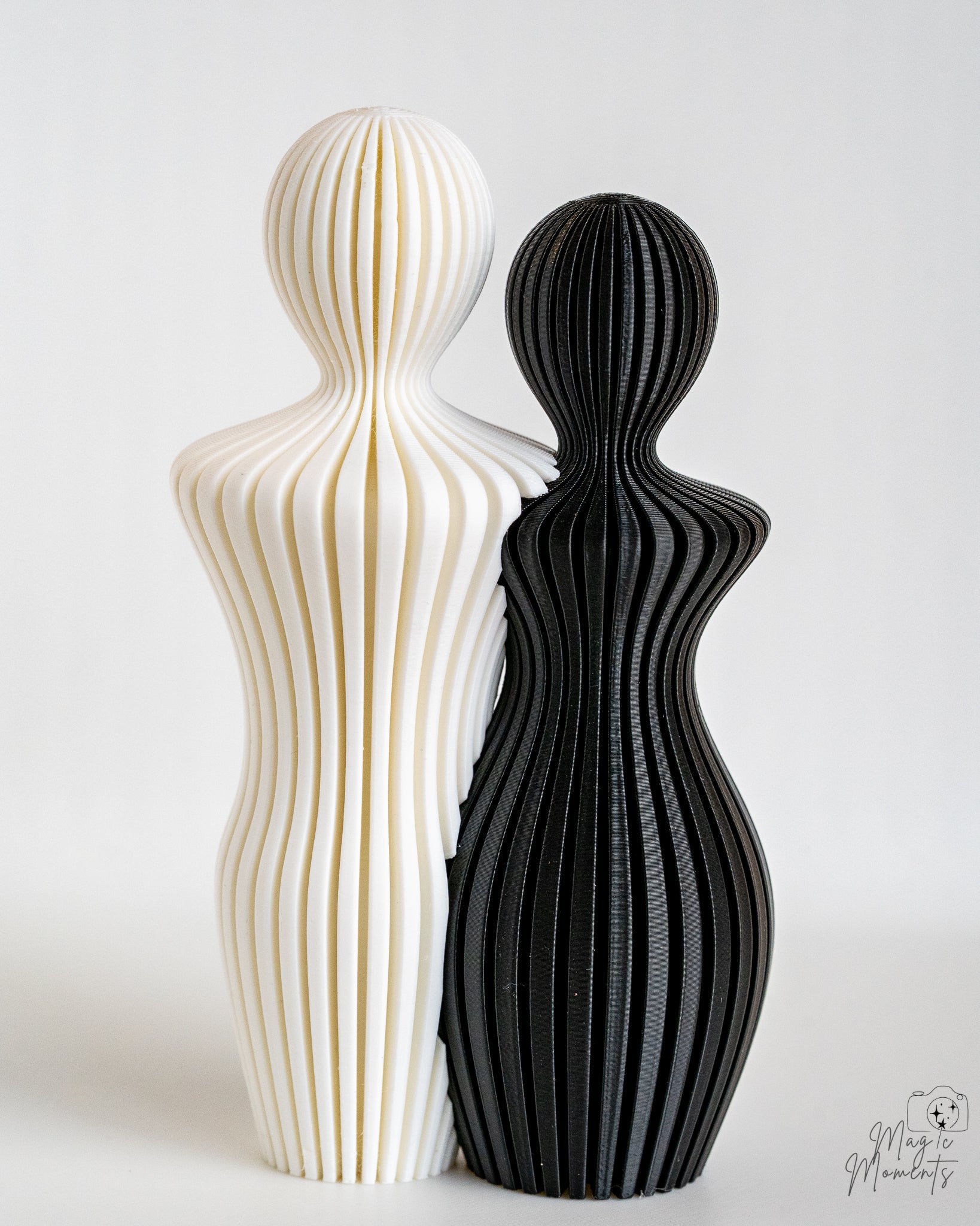 White and black abstract couple sculpture with layered ribbed detail
