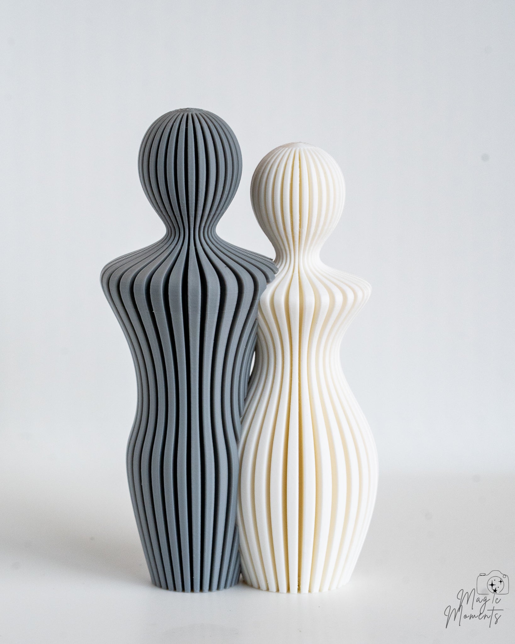 Grey and white abstract sculpture pair with flowing ribbed texture