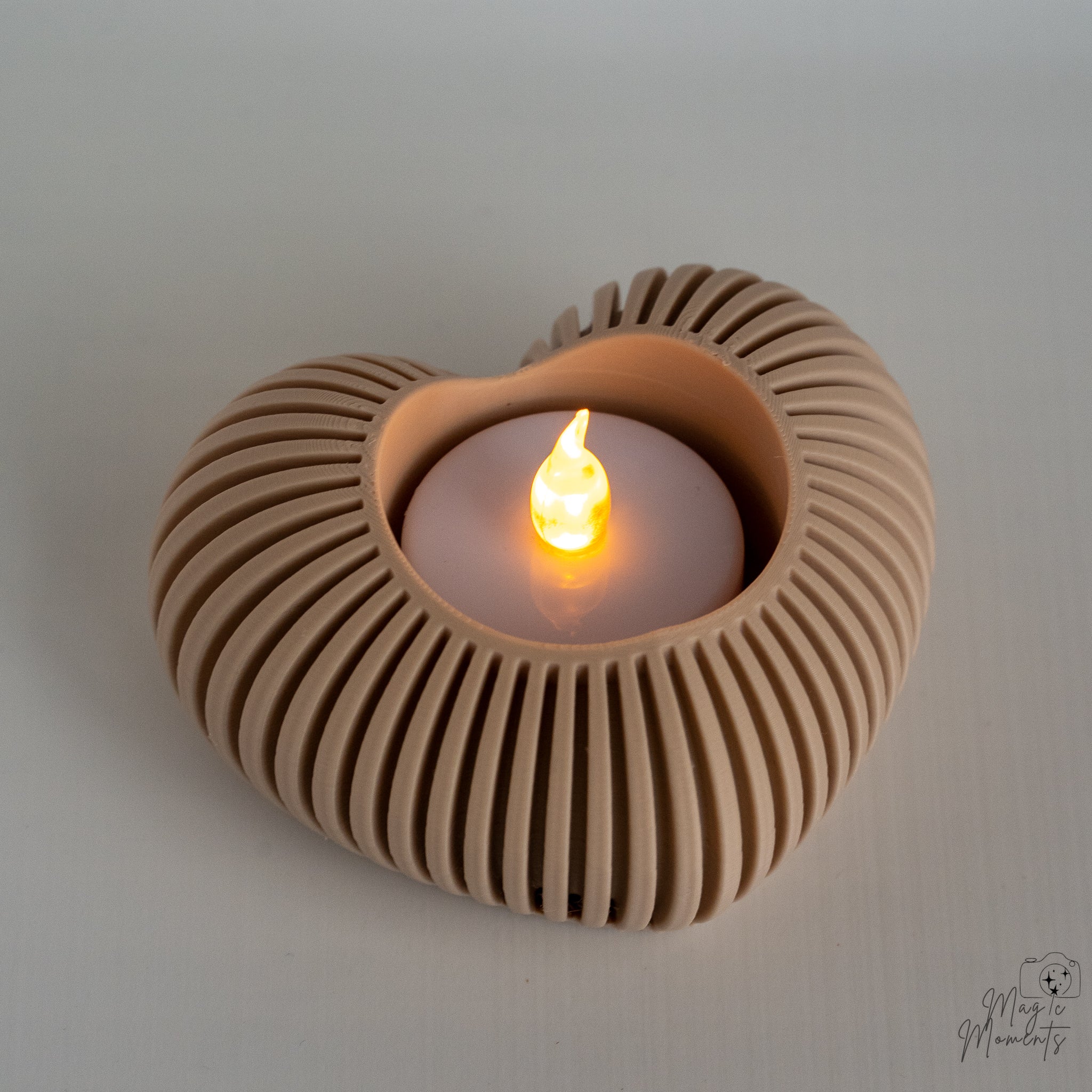 Beige heart tealight holder with warm candle glow