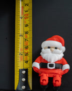 mini santa claus christmas figure next to measuring tape for scale