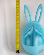 Blue Easter egg container next to measuring tape for scale