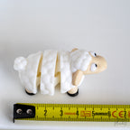 sheep figurine next to measuring tape for scale