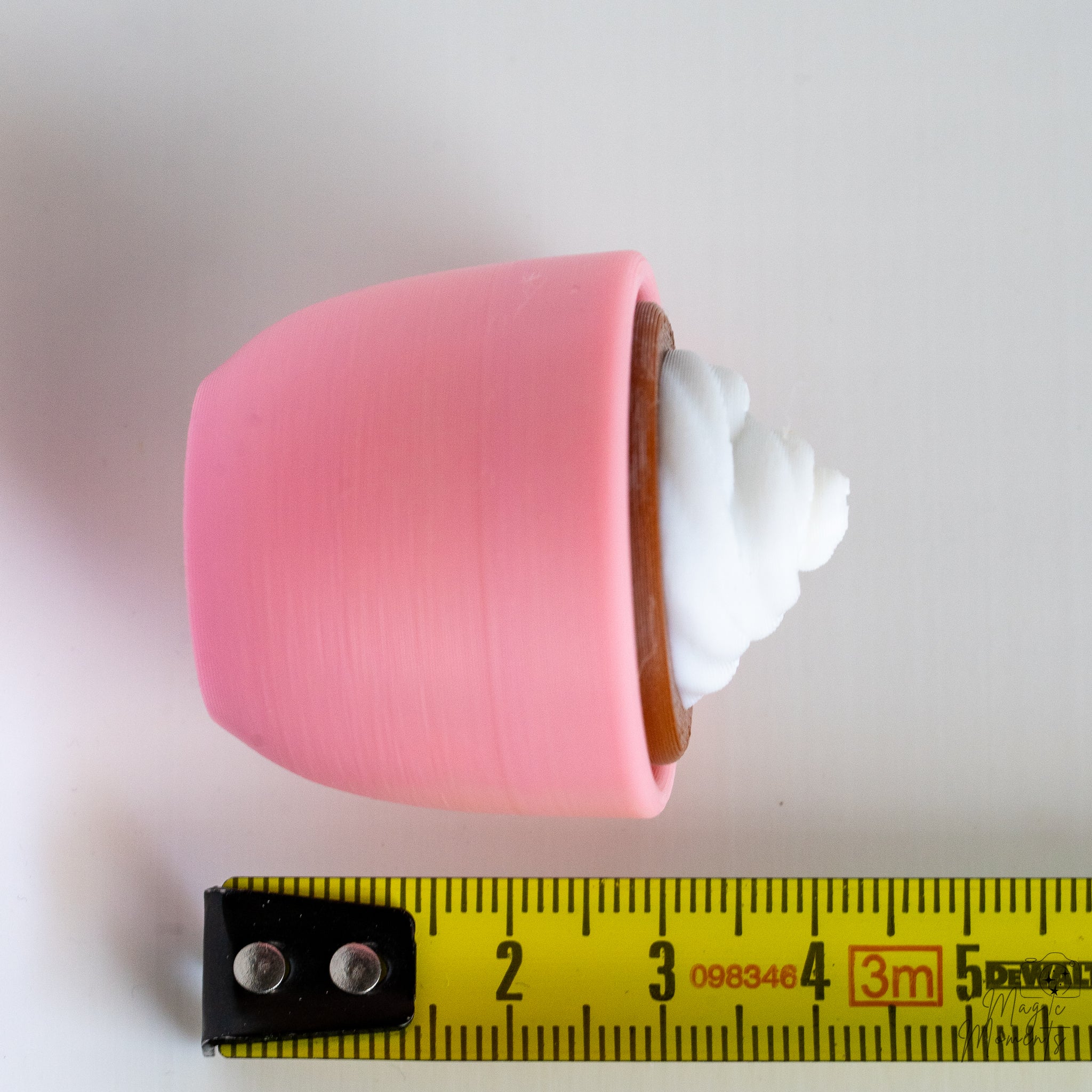 coffee mug clicker next to measuring tape for scale