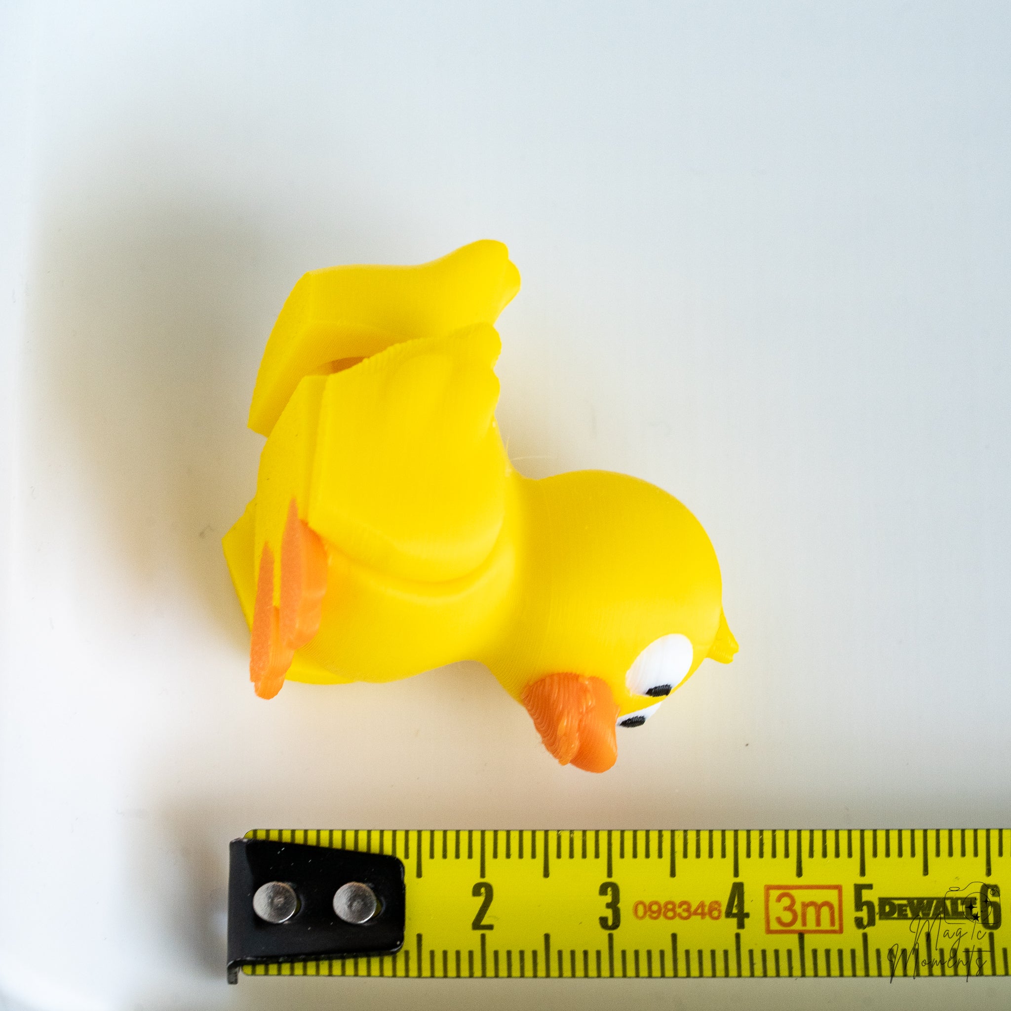 duck figurine next to measuring tape for scale