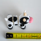 cow figurine next to measuring tape for scale