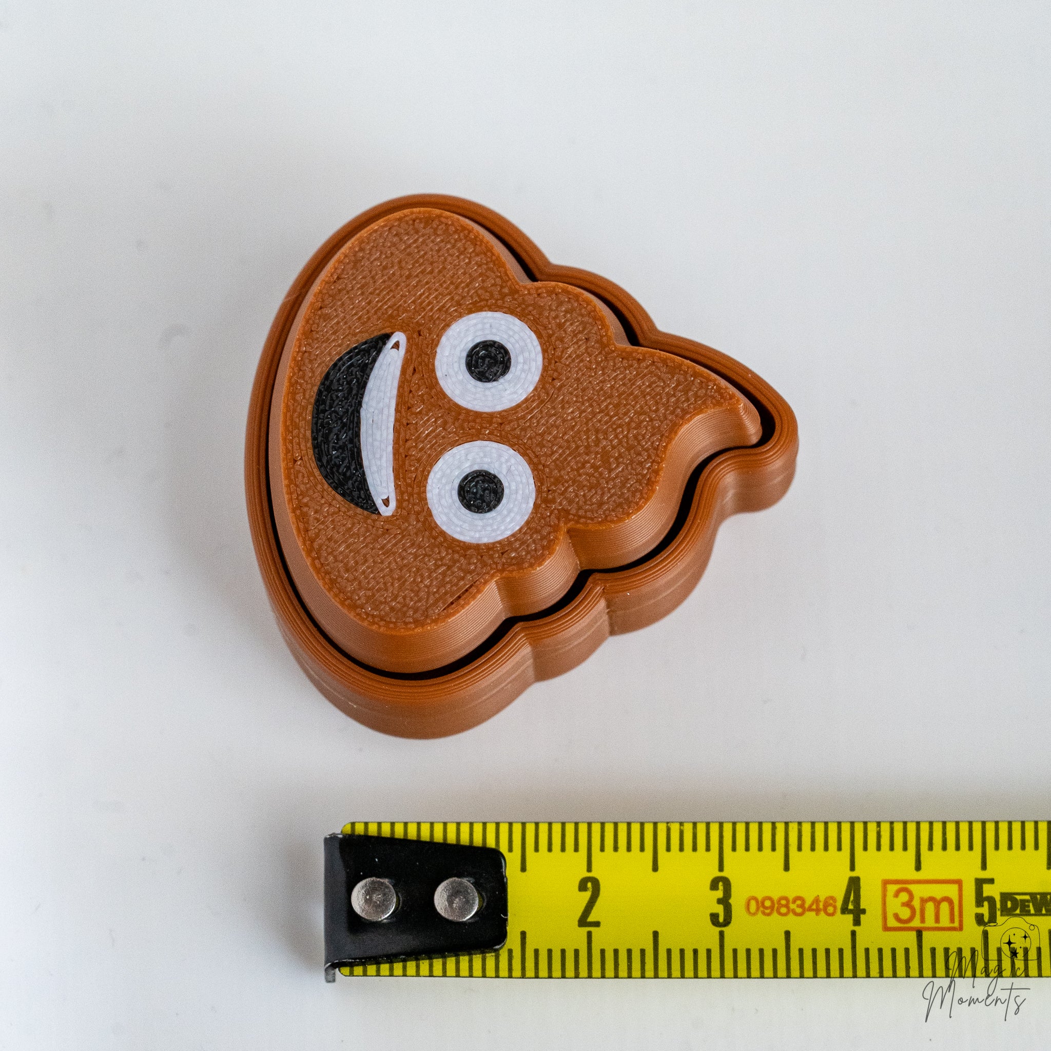 poop emoji keychain next to measuring tape for scale