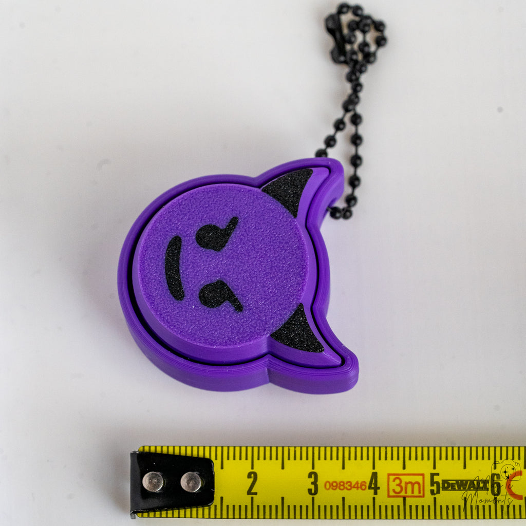 devil emoji keychain next to measuring tape for scale